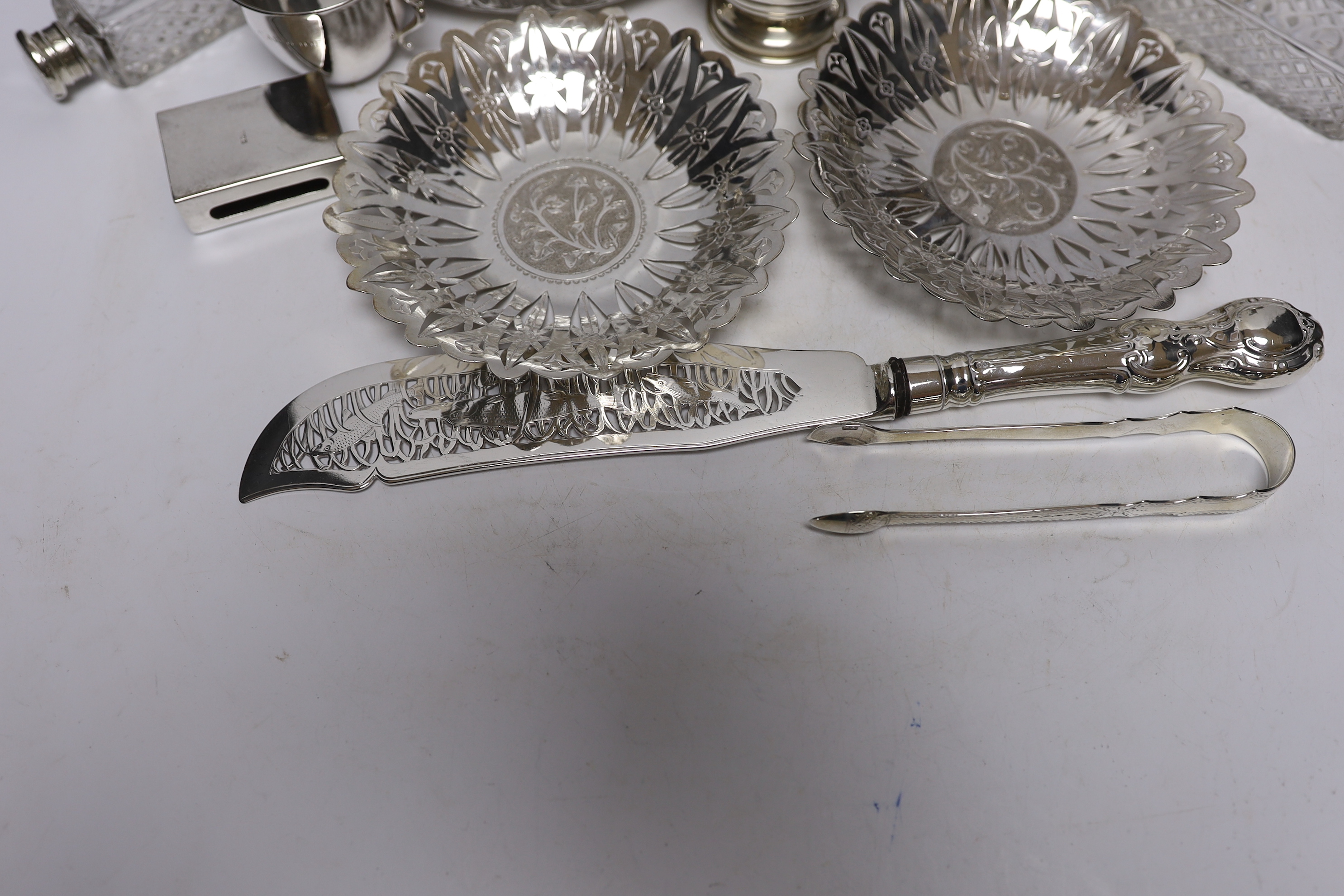 A group of silver and a white metal items including two Middle Eastern ring vases, two foliate dishes, a vase and a canister, together with a silver christening mug, 800 standard beaker, silver fish slice, two mounted gl